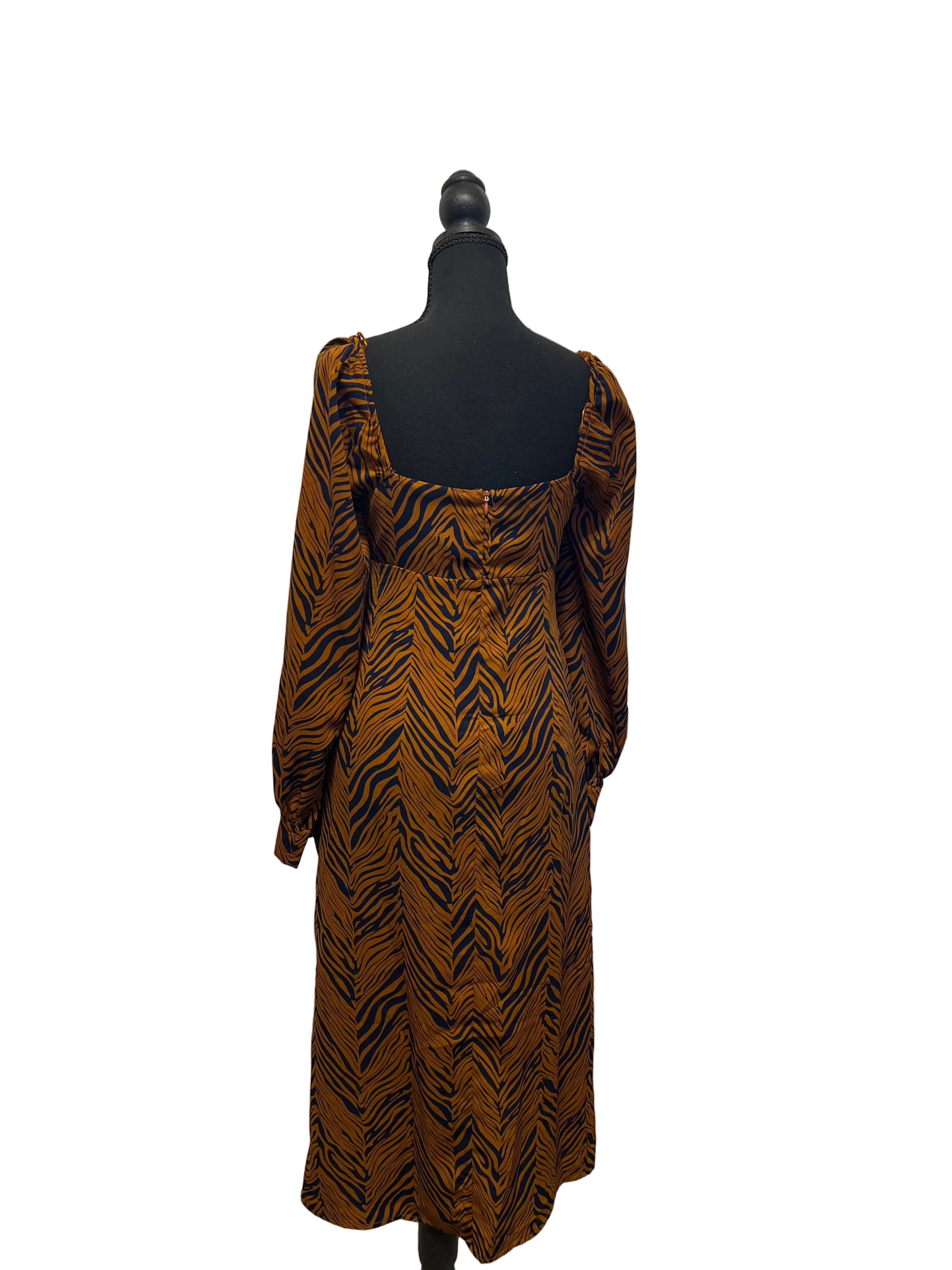 All In Favor multicolor long-sleeve midi dress with rust, brown and black print, shown from the back on a black mannequin.
